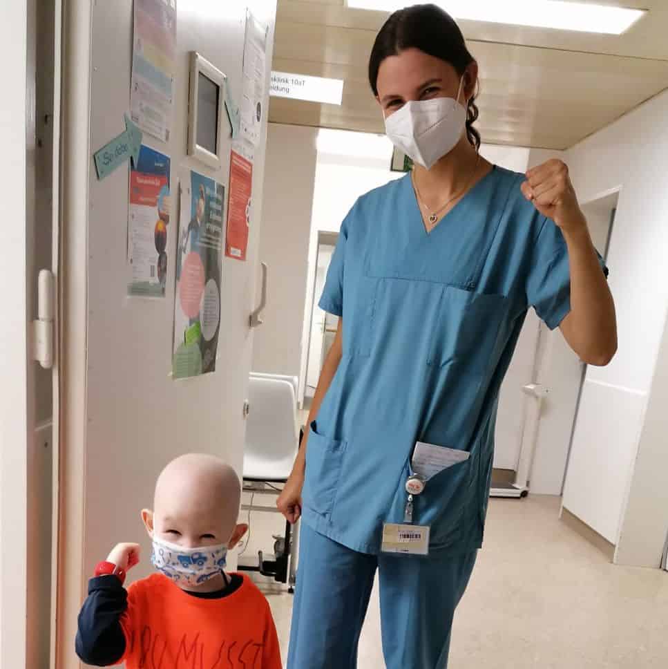 haarloses Kind und Pflegeperson ballen die Fäuste Nahaufnahme