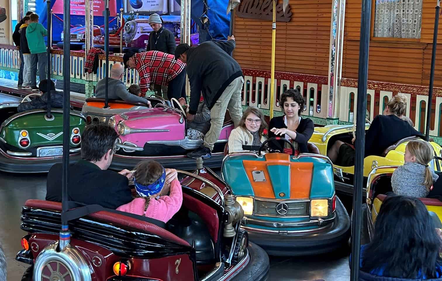Erwachsene mit Kindern fahren Auto Scooter