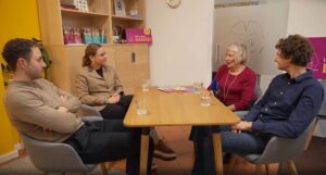 4 Personen sitzen an einem Tisch