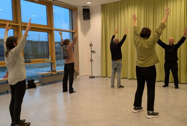 Menschen mit erhobenen Händen in Sporthalle