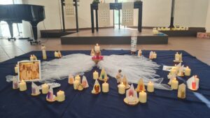 Kirchenraum mit blauer Decke voller brennender kerzen vor dem Altar