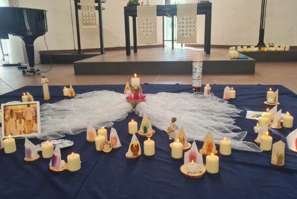 Kirchenraum mit blauer Decke voller brennender kerzen vor dem Altar