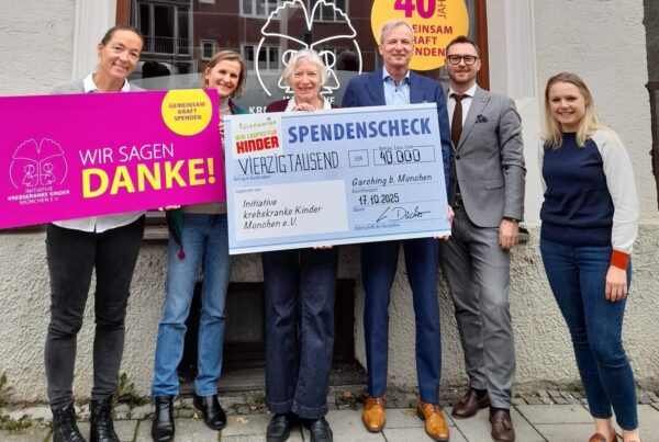 6 Personen mit Spendenscheck vor Ladenbüro
