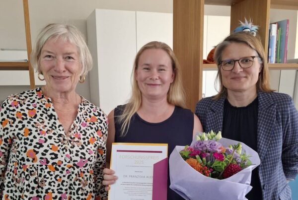 3 Frauen, die mittlere mit Urkunde und Blumenstrauss