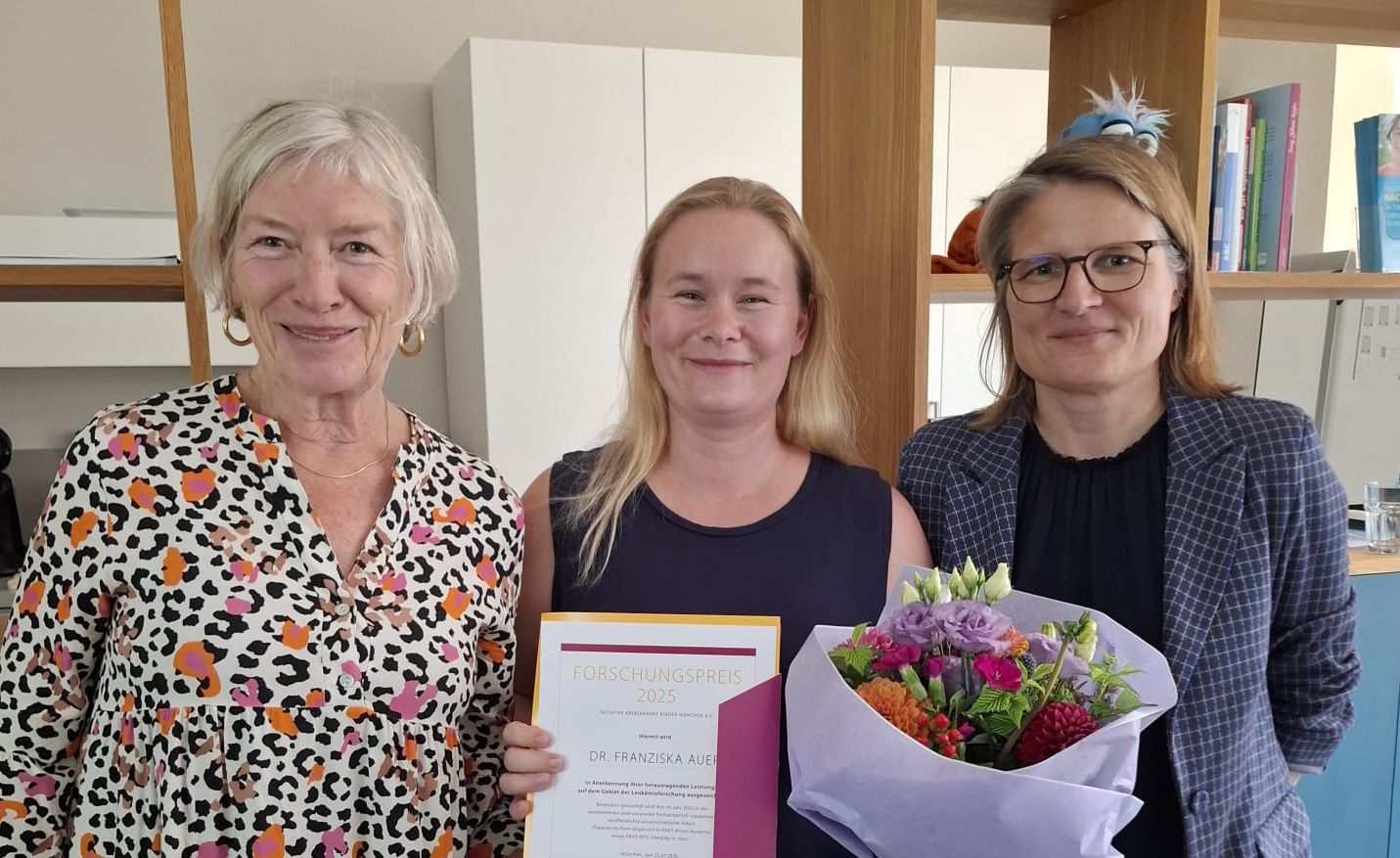 3 Frauen, die mittlere mit Urkunde und Blumenstrauss