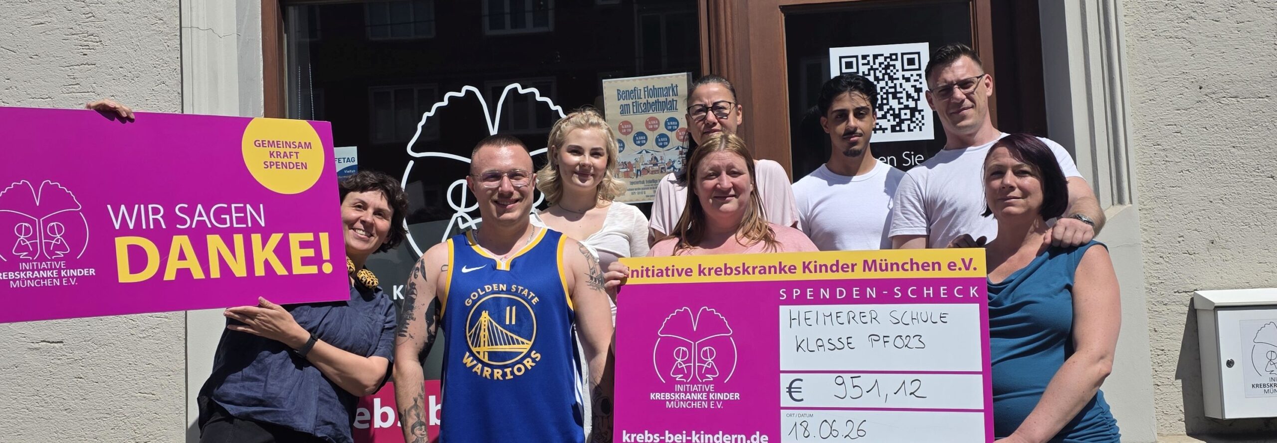 8 Personen mit Spende vor dem Büro