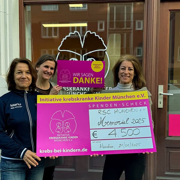 Drei Frauen vor dem Büro der Initiative krebskranke Kinder halten einen großen Spendenscheck