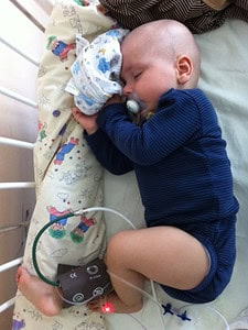 Baby im Gitterbett mit Katheder
