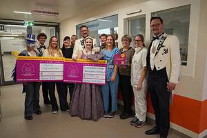 Gruppe Faschingsverein auf dem Flur der Kinderkrebsstation übergibt 2 Spendenschecks