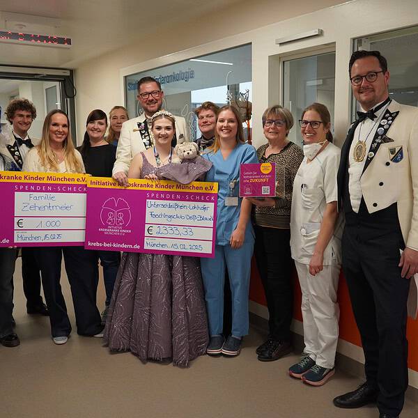 Gruppe Faschingsverein auf dem Flur der Kinderkrebsstation übergibt 2 Spendenschecks
