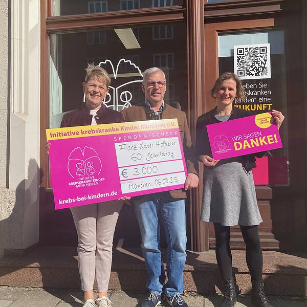 drei Personen mit Spendenscheck und Dankeschild
