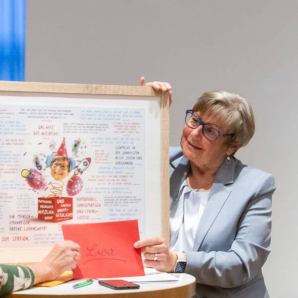 A.Andrae überreicht Lisa eine Tafel mit Zitaten und Bilden