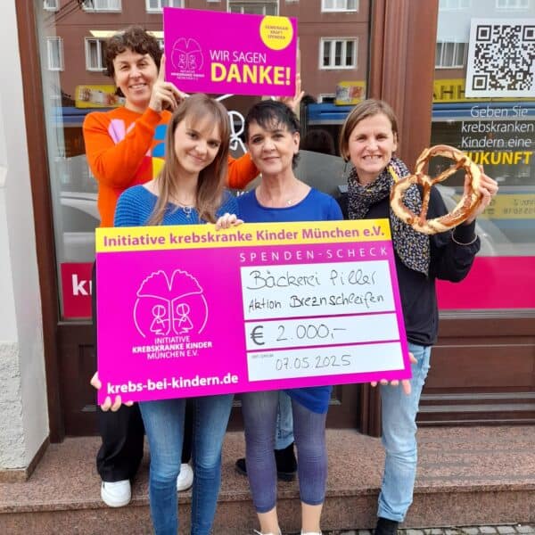 4 Frauen mit Spendenscheck vor dem Ladenbüro