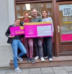3 Frauen 1 Mann zeigen den Spendenscheck.