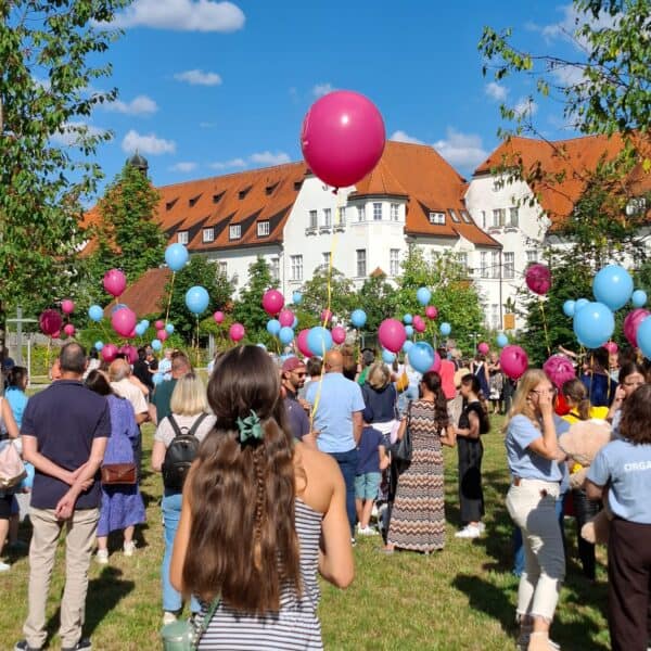 viele Menschen mit Luftballons in einem Park