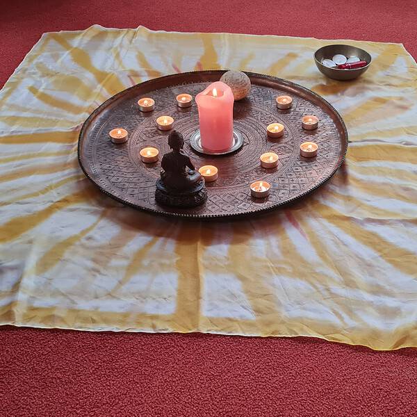 Tuch mit Sonnenstrahlen, darauf eine Schale mit Kezen