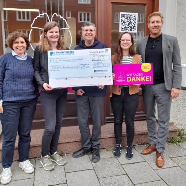 3 Frauen und 2 Männer stehen mit Spendenscheck vor dem Ladenbüro