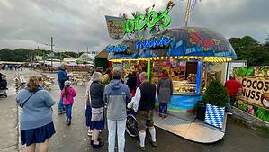 Familie steht vor Süßigkeitenstand auf der Wiesn