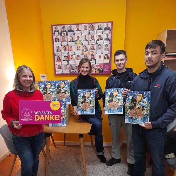 4Personen im Büro halten Adventskalender